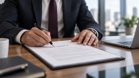 A legal professional reviews and marks a commercial contract at a desk.